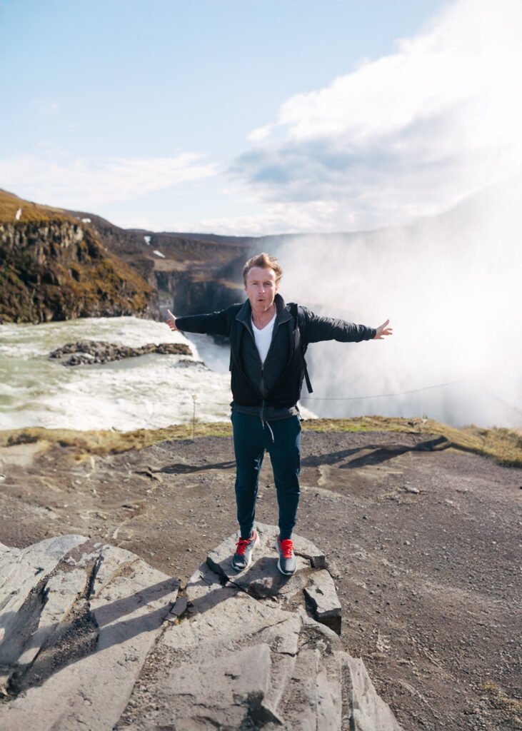 Tim in iceland next to a huge waterfall. Minneapolis